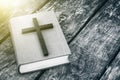 Closeup of wooden Christian cross on bible on the old table. Royalty Free Stock Photo