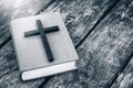 Closeup of wooden Christian cross on bible on the old table. Royalty Free Stock Photo