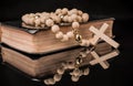 Closeup of wooden Christian cross on bible and prayer beads on black.Church utensils Royalty Free Stock Photo