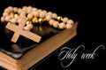 Closeup of wooden Christian cross on bible and prayer beads on black.Church utensils Royalty Free Stock Photo