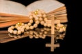 Closeup of wooden Christian cross on bible and prayer beads on black.Church utensils Royalty Free Stock Photo