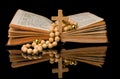 Closeup of wooden Christian cross on bible and prayer beads on black.Church utensils Royalty Free Stock Photo