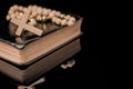 Closeup of wooden Christian cross on bible and prayer beads, Church utensils Royalty Free Stock Photo