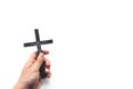 Church utensils. Man holding a crucifix. Closeup of wooden christian cross in the hand on the white isolated background. Royalty Free Stock Photo