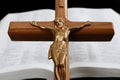 Close-up of wood cross with Jesus Christ ahead of open Bible Royalty Free Stock Photo