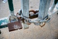 Closeup wooden door on the private road,locked with a chain and a rusty padlock Royalty Free Stock Photo