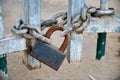 Closeup wooden door on the private road,locked with a chain and a rusty padlock Royalty Free Stock Photo