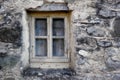 Closeup of a wooden frame window on ancient house in a village. Exterior of old dirty window and wall on farmhouse. A Royalty Free Stock Photo