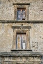 Closeup of a wooden frame window on ancient house in a village. A small window and grey stone or brick wall of an old Royalty Free Stock Photo