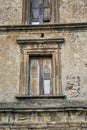 Closeup of a wooden frame window on ancient house in a village. A small window and grey stone or brick wall of an old Royalty Free Stock Photo