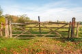 Closeup of a wooden gate closed with knotted orange-colored rop Royalty Free Stock Photo