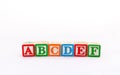 Closeup wooden letter toy arranged the word ABCDEF in a row isolated on white background