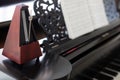 Closeup of wooden metronome on an old black piano Royalty Free Stock Photo