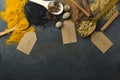 Top view of cinnamon, anise, turmeric, sesamum, powder spices, wooden spoon, paper tag on the dark rustic table.Empty space for te Royalty Free Stock Photo