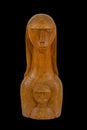 Closeup of a wooden statue of a female with a baby isolated on a black background