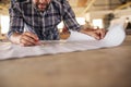 Woodworker leaning on a bench reading furniture design blueprints Royalty Free Stock Photo