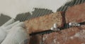 Closeup worker applying brick cuts tile to the wall