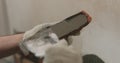 Closeup worker applying concrete glue to brick cuts tile