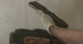 Closeup worker applying concrete glue to brick cuts tile