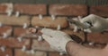 Closeup worker applying concrete glue to brick tile