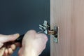 Closeup of worker`s hands fitting wardrobe hinge doors in closet Royalty Free Stock Photo