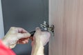 Closeup of worker`s hands fitting wardrobe hinge doors in closet Royalty Free Stock Photo