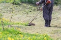 Closeup of a worker in special clothes with a gas mower in his hand Royalty Free Stock Photo