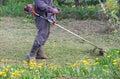 Closeup of a worker in special clothes with a gas mower in his hand Royalty Free Stock Photo