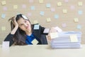 Closeup working woman are boring from pile of hard work and work paper in front of her in work concept on blurred wooden desk and