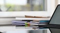 Closeup workspace computer tablet with keyboard case putting on modern working desk with stack of notebooks and books. Royalty Free Stock Photo