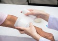 Closeup wound dressing An Elderly Person. doctor suing bandage covering on senior womanÃ¢â¬â¢s arm at home, wearing glove to protect Royalty Free Stock Photo