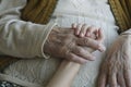 Closeup wrinkled hand holding a younger hand Royalty Free Stock Photo