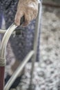 Wrinkled hand of an old woman holding on to a walker at home Royalty Free Stock Photo