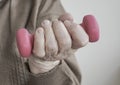 Closeup wrinkled hand of a senior person holding dumbbell
