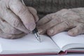 Closeup wrinkled hands of a person writing