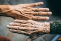 Closeup of a wrinkly and a young person& x27;s hands on a blurred background