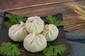 Closeup of xiaolongbao Chinese steamed bun on black plate, wood background Royalty Free Stock Photo