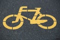 Closeup of yellow bicycle sign on the bike lane in the park Royalty Free Stock Photo