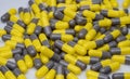 Closeup yellow and gray capsule pills on white background. Prescription drugs. Pharmaceutical industry. Health and medical care