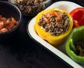 Phases of stuffed bell peppers on dark background