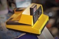 Closeup of a yellow impulse polaroid camera with a blurry background