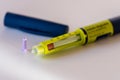 Closeup of a yellow insulin injector of disposable type