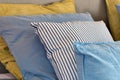 Closeup of Yellow and light blue pillows in a row on the bed, modern retro decoration for home, pastel light colors colorful Royalty Free Stock Photo