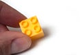 Yellow plastic bricks construction in hand on white background Royalty Free Stock Photo