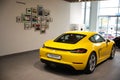 Closeup of a yellow Porsche parked in a modern showroom under the bright light in Armenia