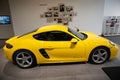 Closeup of a yellow Porsche parked in a modern showroom under the bright light in Armenia