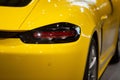 Closeup of a yellow Porsche parked in a modern showroom under the bright light in Armenia