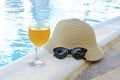 Closeup of yellow straw hat and black protective sunglasses, goggles, fresh orange juice smoothie drink cocktail on