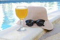 Closeup of yellow straw hat and black protective sunglasses, goggles, fresh orange juice smoothie drink cocktail on