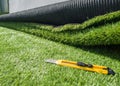 Closeup of a yellow utility knife on the green meadow outdoors